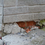 Foundation house wall damage from wetness. Foundation walls without waterproofing. Cracked foundation wall corner.